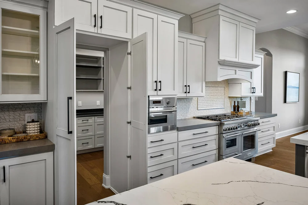 Custom kitchen with white cabinetry and a stone island