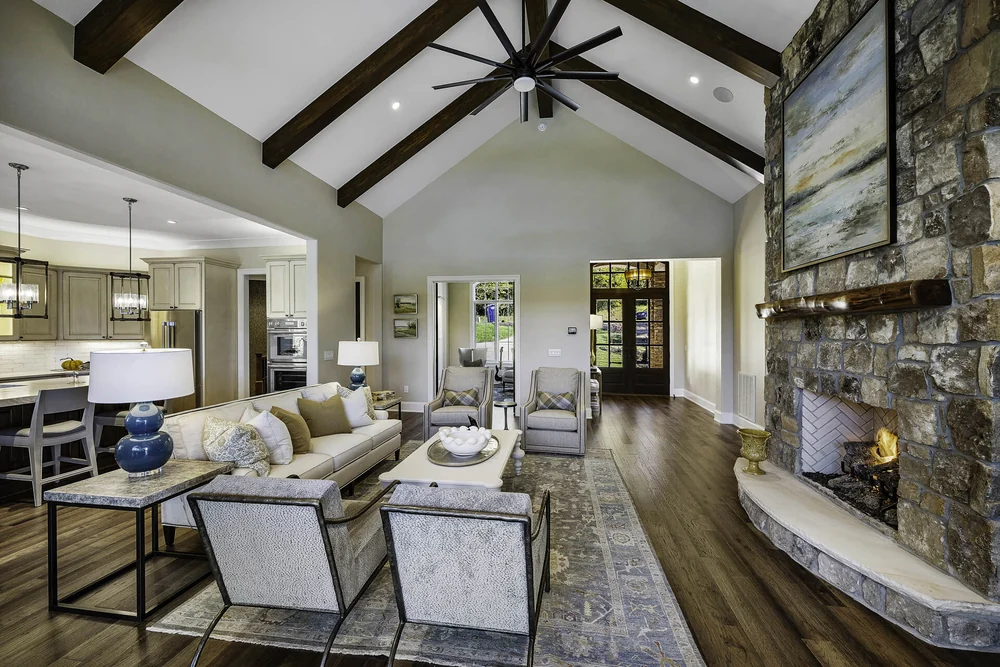 Light-filled living room with timber beams and a stone fireplace