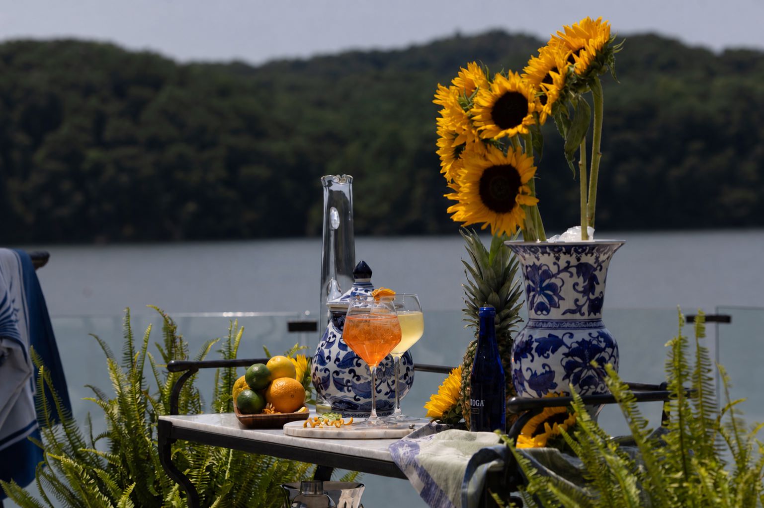 Finished lakefront terrace styled with coral and golden citrus drinks