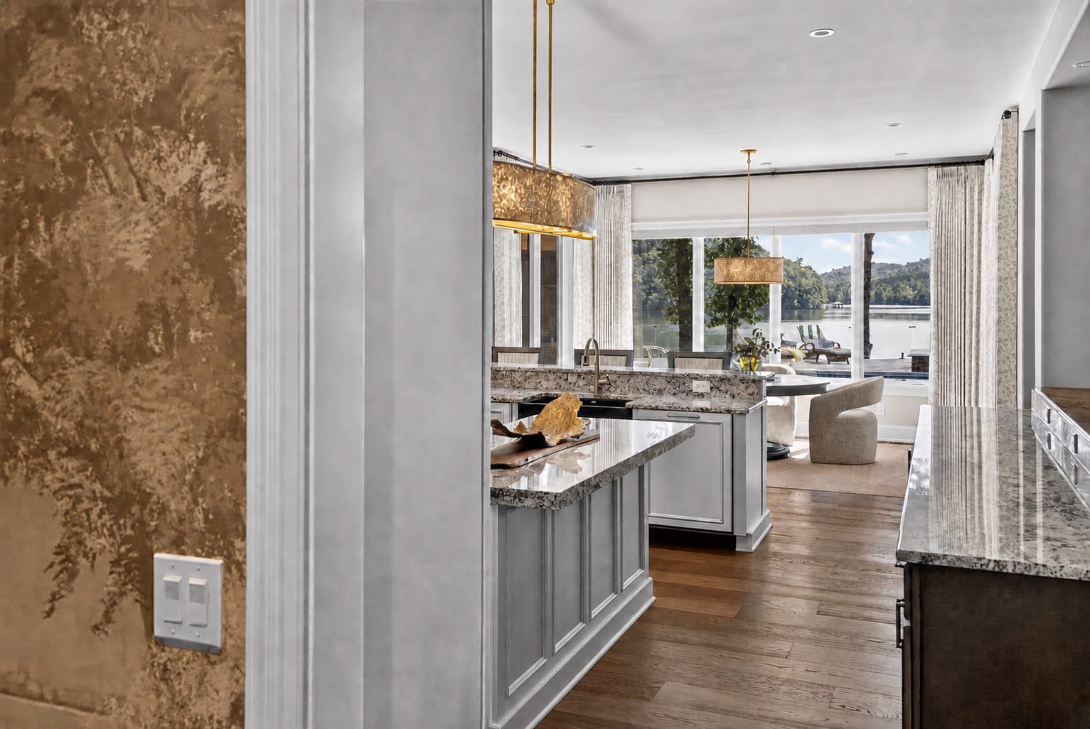 Finished custom kitchen with warm pendant lighting, viewed through a decorative entry wall