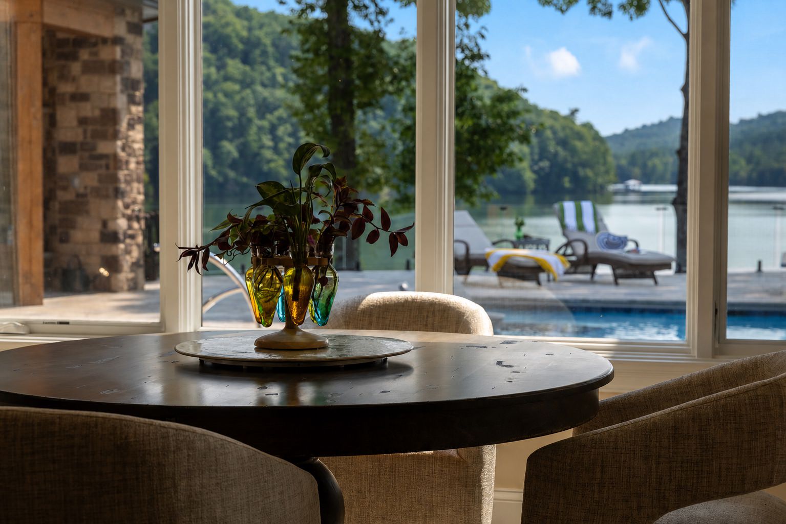 Finished breakfast nook overlooking a lakefront pool beneath a clear blue sky